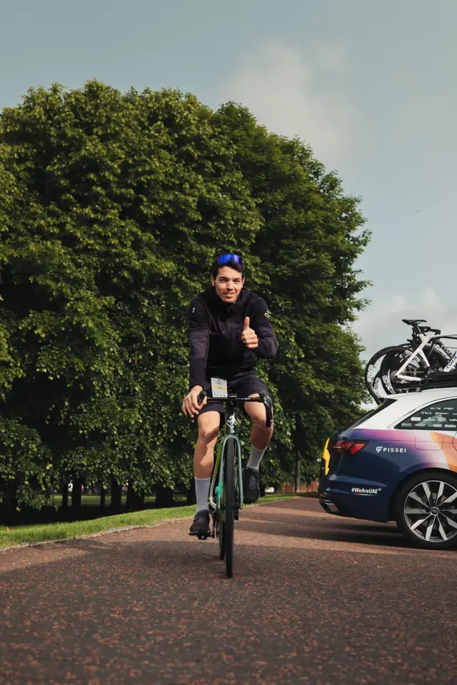 Kike Collado en bici, saludando con el pulgar arriba