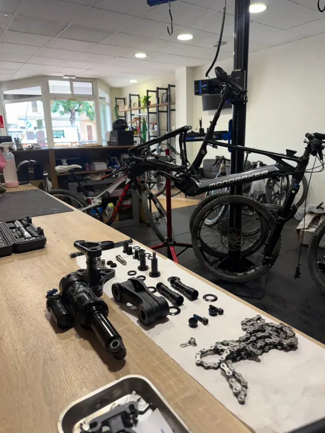 E-bike Mondraker en el soporte del taller con su amortiguador desmontado